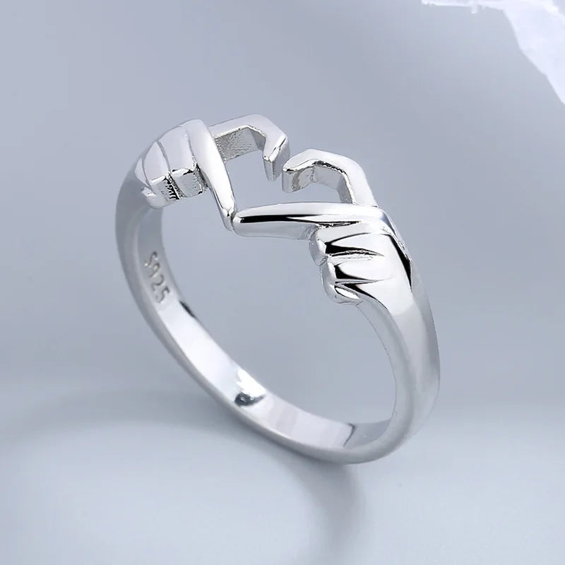 Mano de amor con anillo en forma de corazón